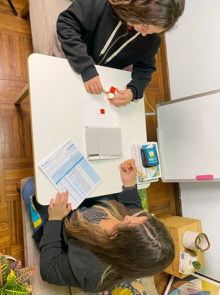Sesión de evaluación WISC-V en la Clínica Psicólogos Peñaflor: la psicóloga registra mientras el niño arma un diseño con cubos