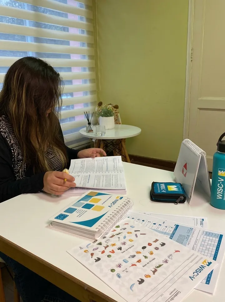Psicóloga revisando el protocolo y los cuadernillos del WISC-V para corregir e interpretar los resultados