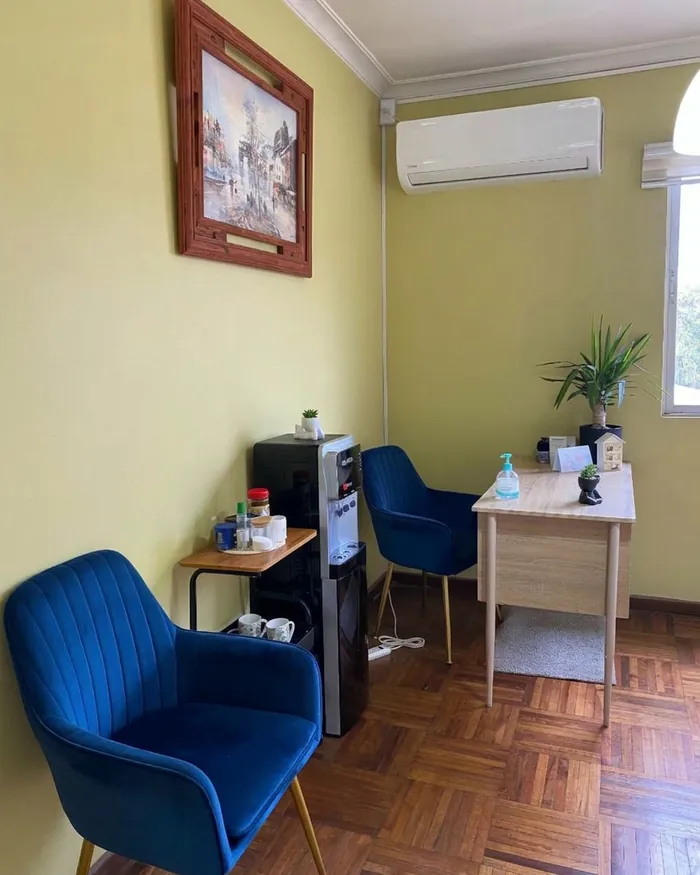 Recepción de la clínica con sillones azules y escritorio