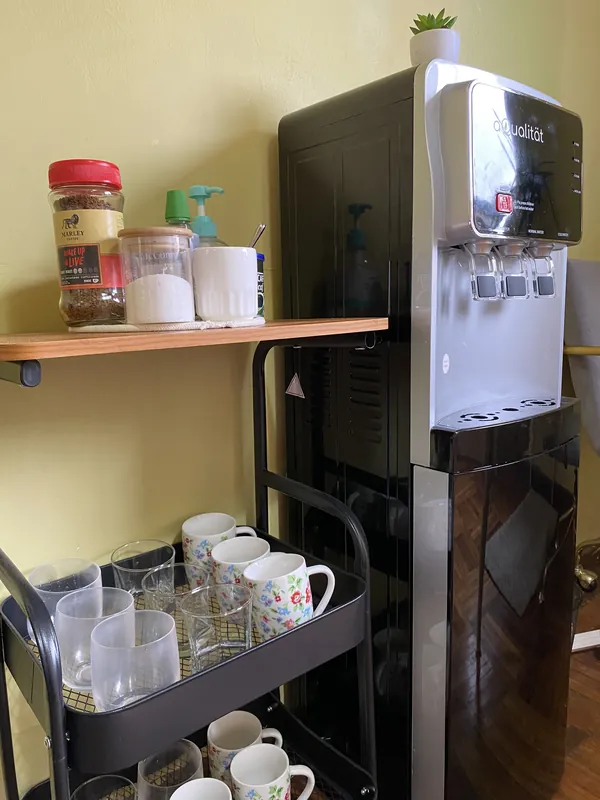 Rincón con café, té, tazas y dispensador de agua para quienes esperan